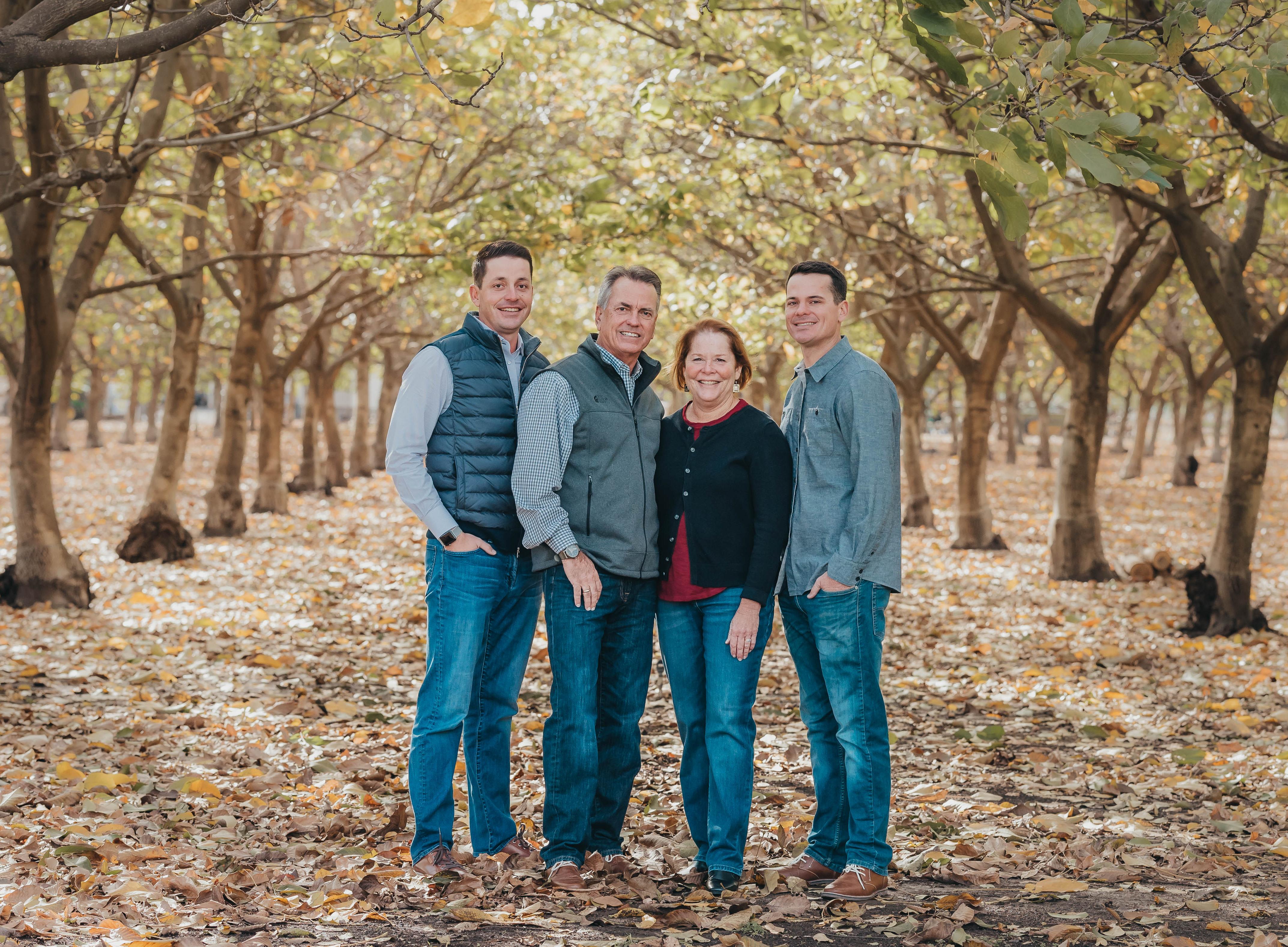 Tod standing at an orchard with his wife and two sons